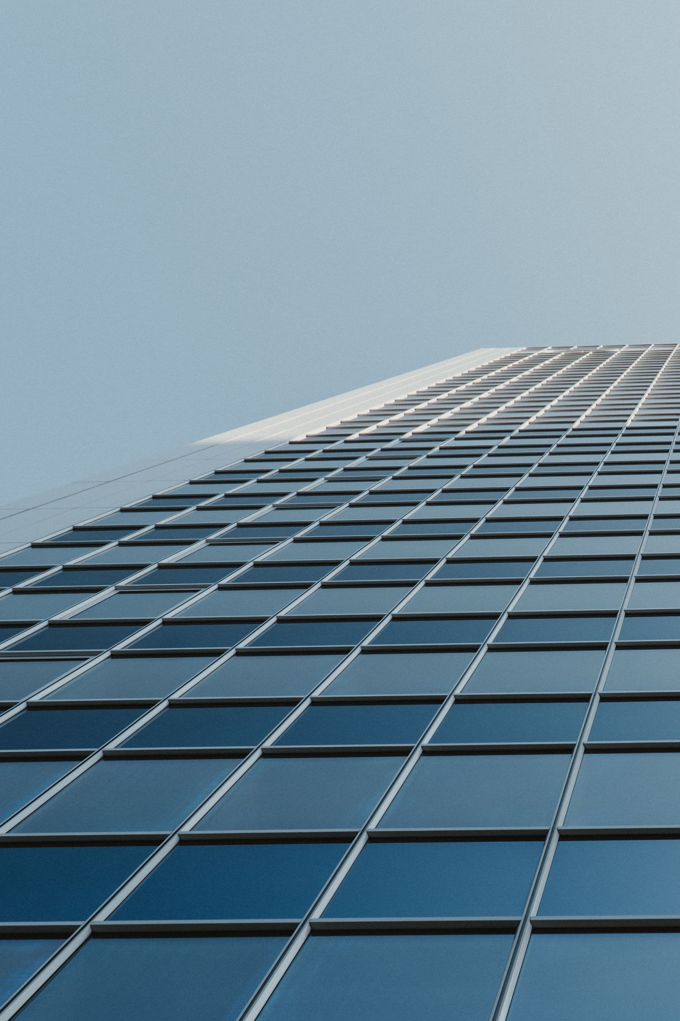 Looking up at a glass office building facade